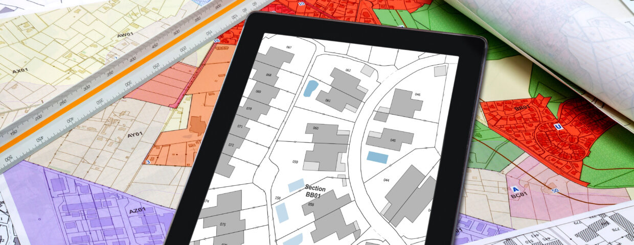 Urbanisme – Aménagement du territoire – Cartes de plan local d’urbanisme et cadastre affiché sur une tablette numérique